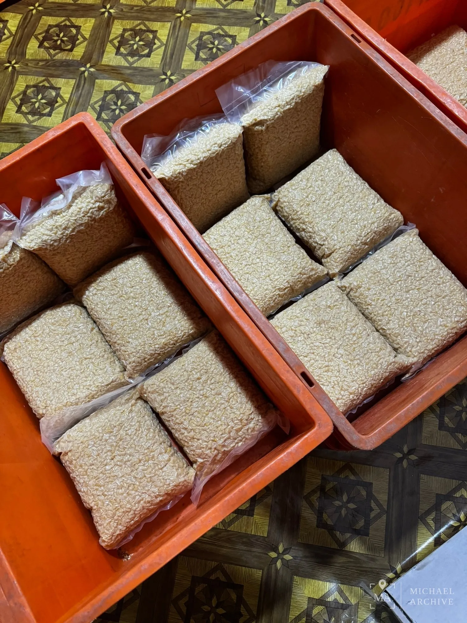 주황색 상자 두 개에 진공포장한 사각 블록이 담겨 있다. 아래 상자의 블록은 갈색이고 위 상자의 블록은 흰색이다.