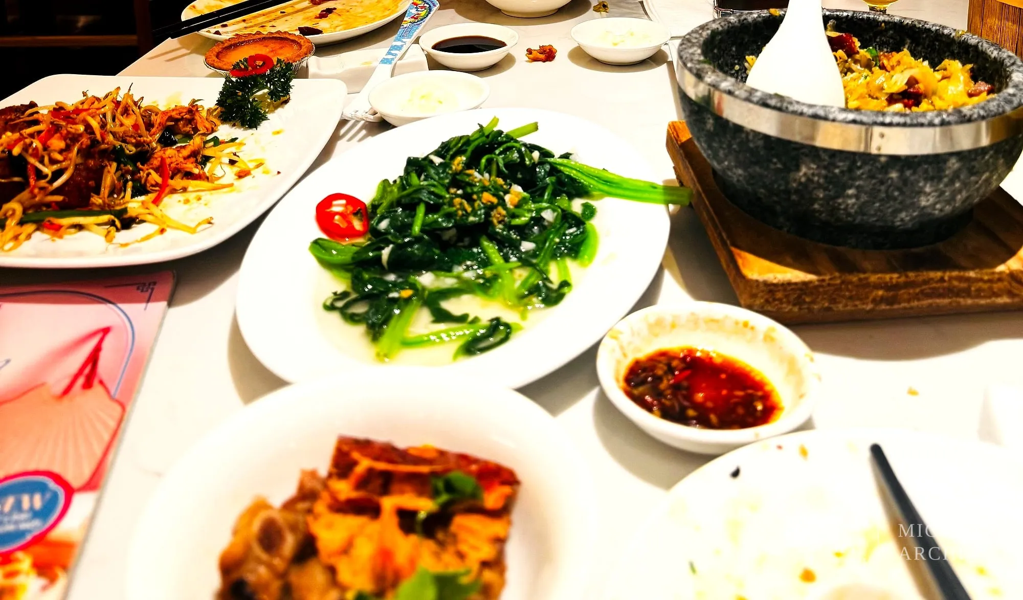크리스탈 제이드 상차림. 볶음면, 청경채 볶음, 돌솥 볶음밥, 간장 종지가 놓여 있다