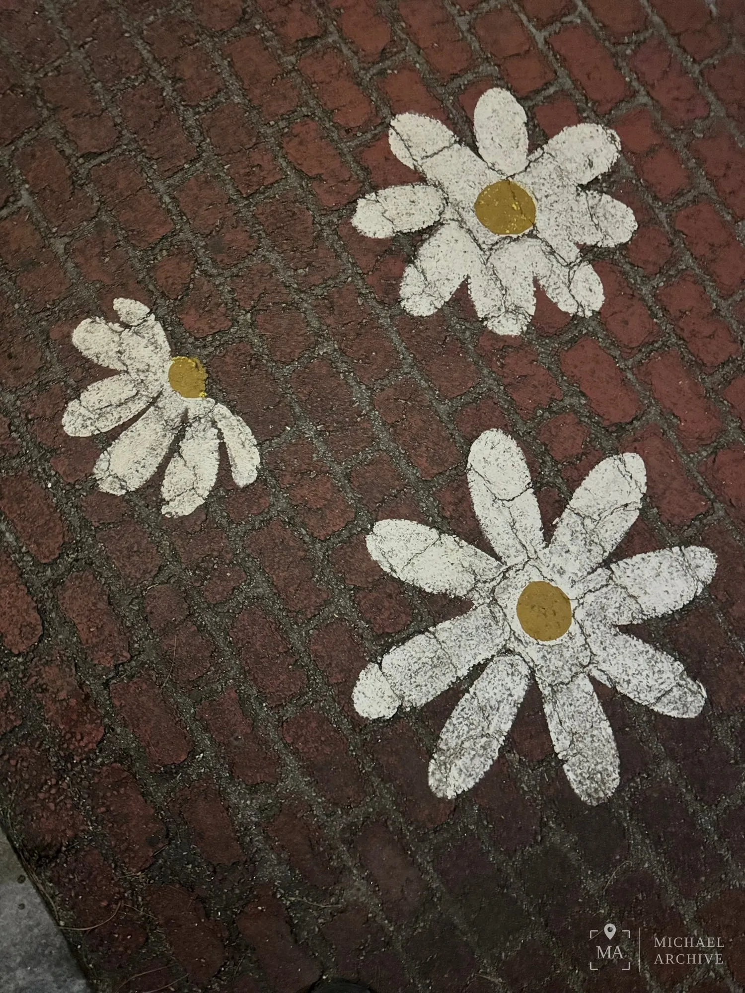 입구 앞 붉은 벽돌 바닥에 그려진 하얀 꽃