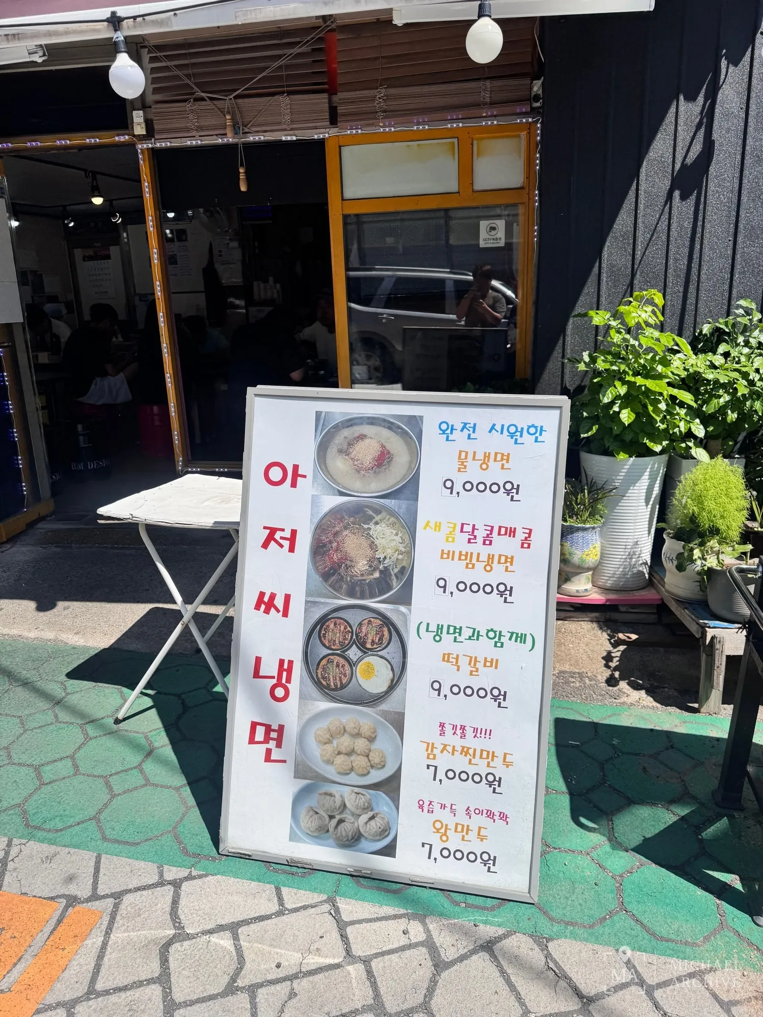 입간판 메뉴 — 물냉면 9,000원, 비빔냉면 9,000원, 떡갈비 9,000원, 감자찐만두 7,000원, 왕만두 7,000원