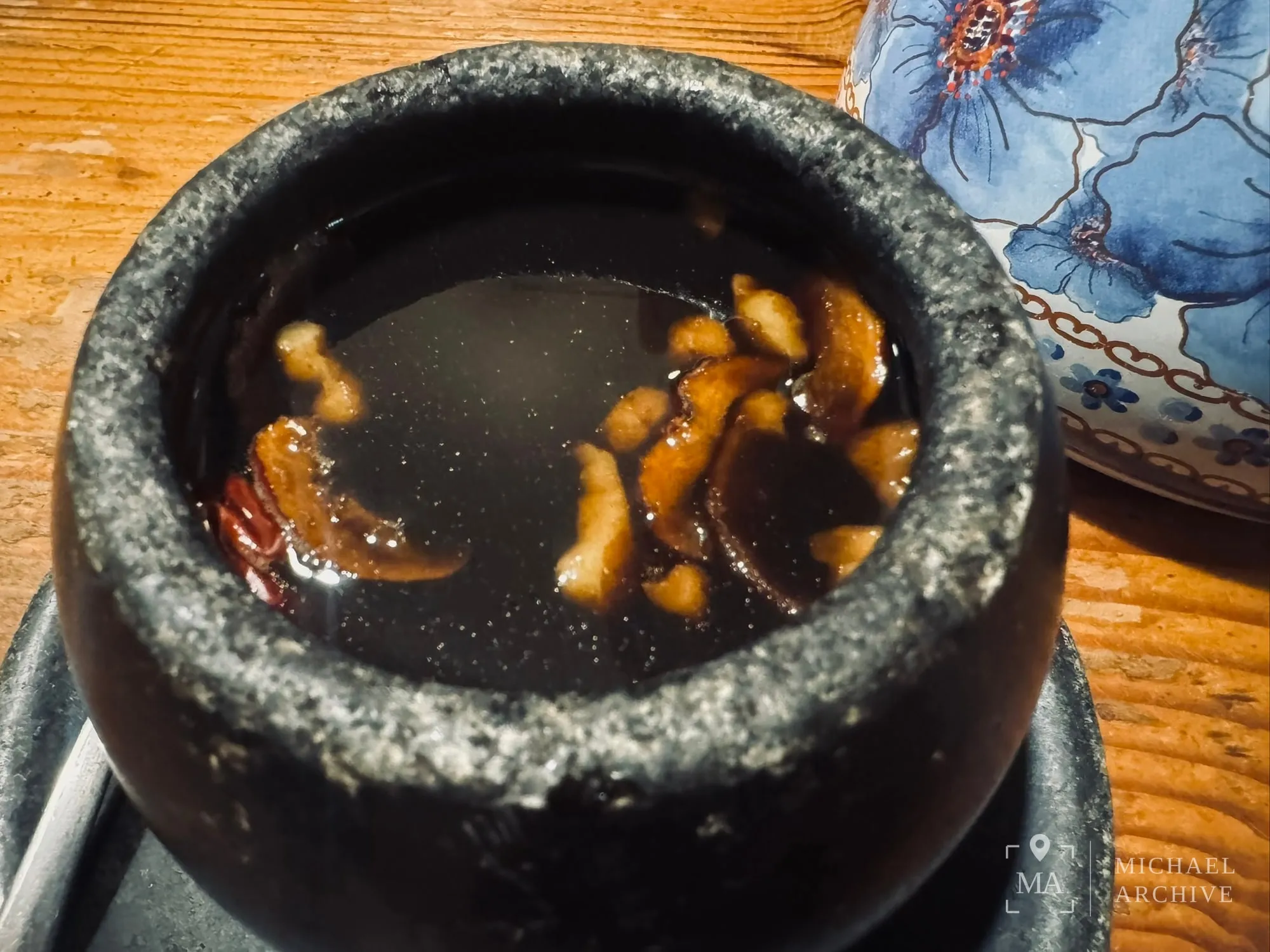 돌잔에 담겨 나온 쌍화차 — 호두와 대추, 붉은 열매 조각이 떠 있다